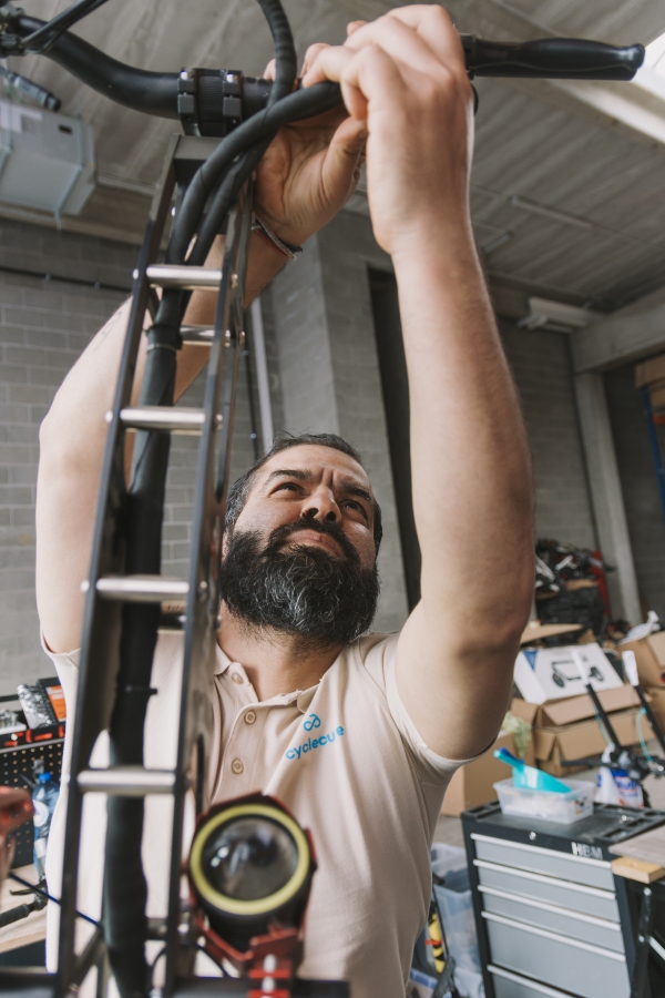 mechanic checking the brake cables of a micro mobility vehicle